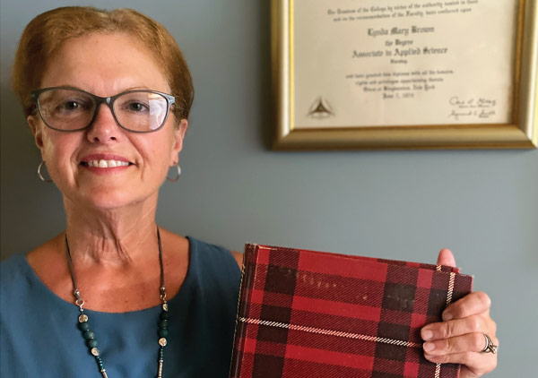 Alumna Lynda Bass holds up her BCC yearbook in front of her 1974 college diploma. 