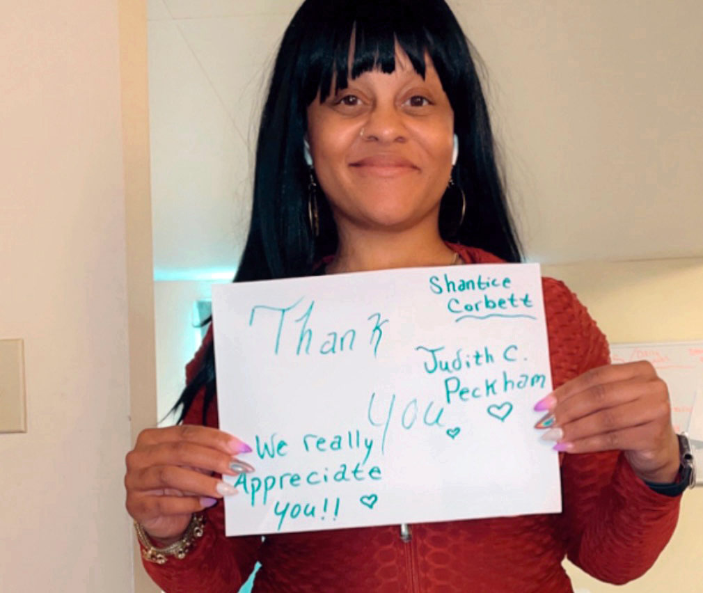 Shantice Corbett  holds a sign that says 'thank you'