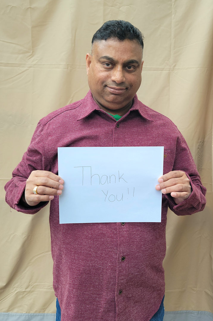 Rony holds a sign that says 'Thank You'.