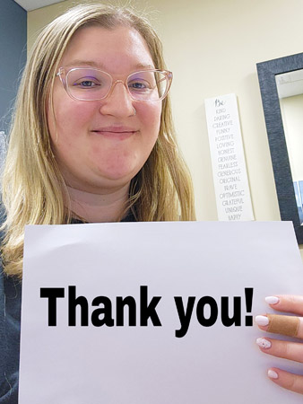 Tosha holds up a sign that says 'thank you'.