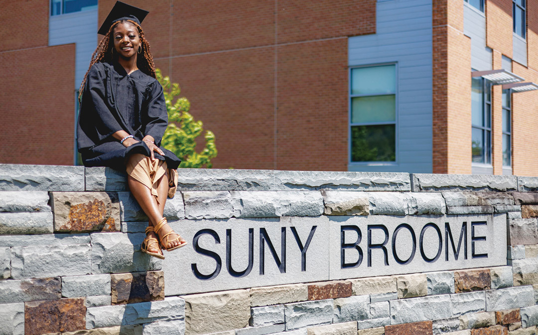 SUNY Broome students posing in their graduation robes.