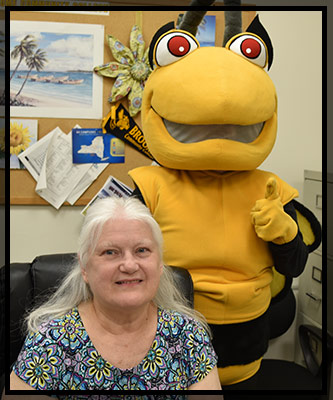 Barb Hughes smiles while Stinger gives a thumbs up.