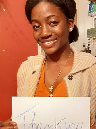 Francia holds up a thank you sign.