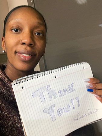 LaDaisha holds up a notepad that says 