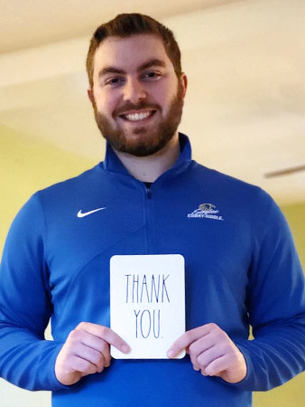 Zachary holds up a thank you notecard.