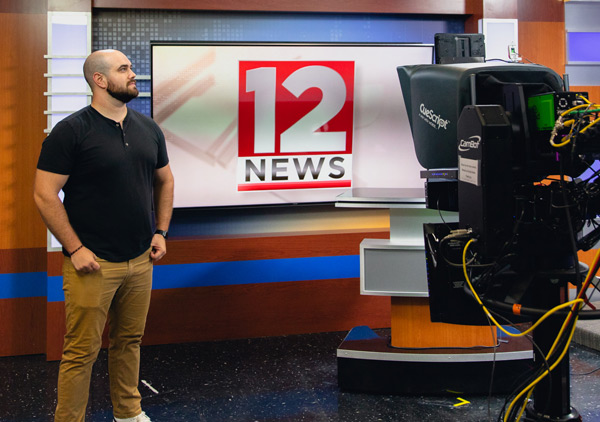 Scott Sasina stands on the newsroom set of WBNG 12 News.