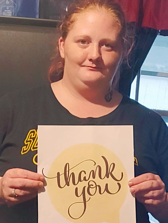 Karlee holds a thank you sign