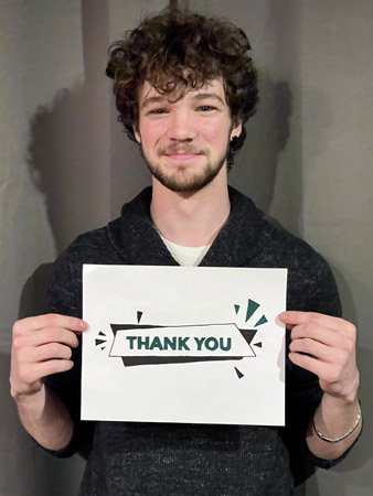 Logan holds a thank you sign