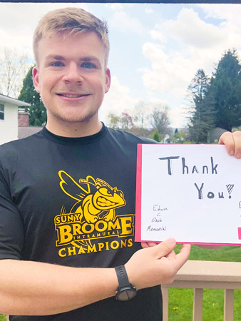 Nicholas holds a thank you sign