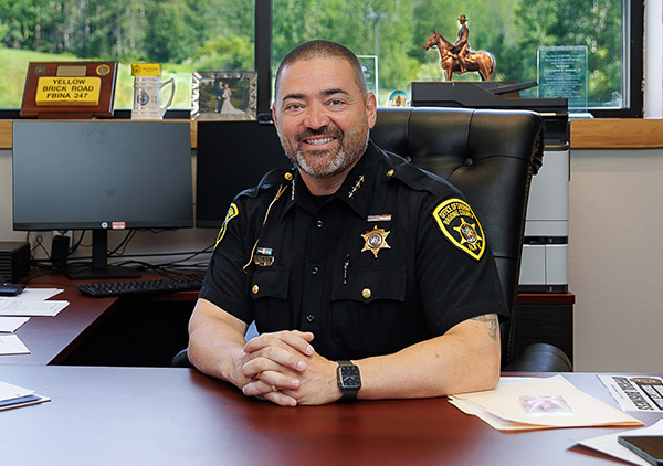 Sheriff Akshar sits at his desk.