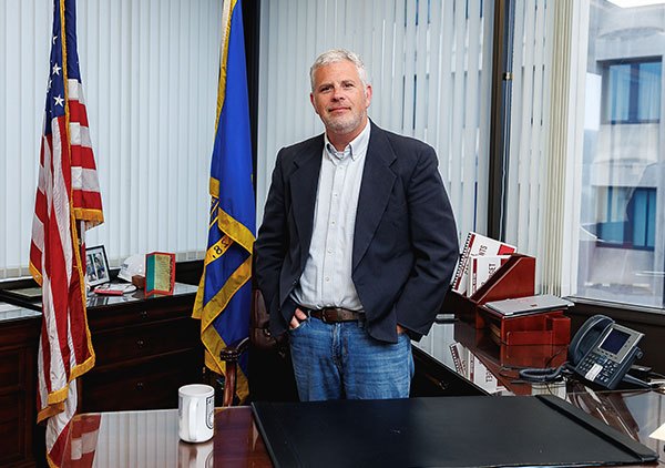 Jason Garnar stands behind his desk in his Broome County Executive office.