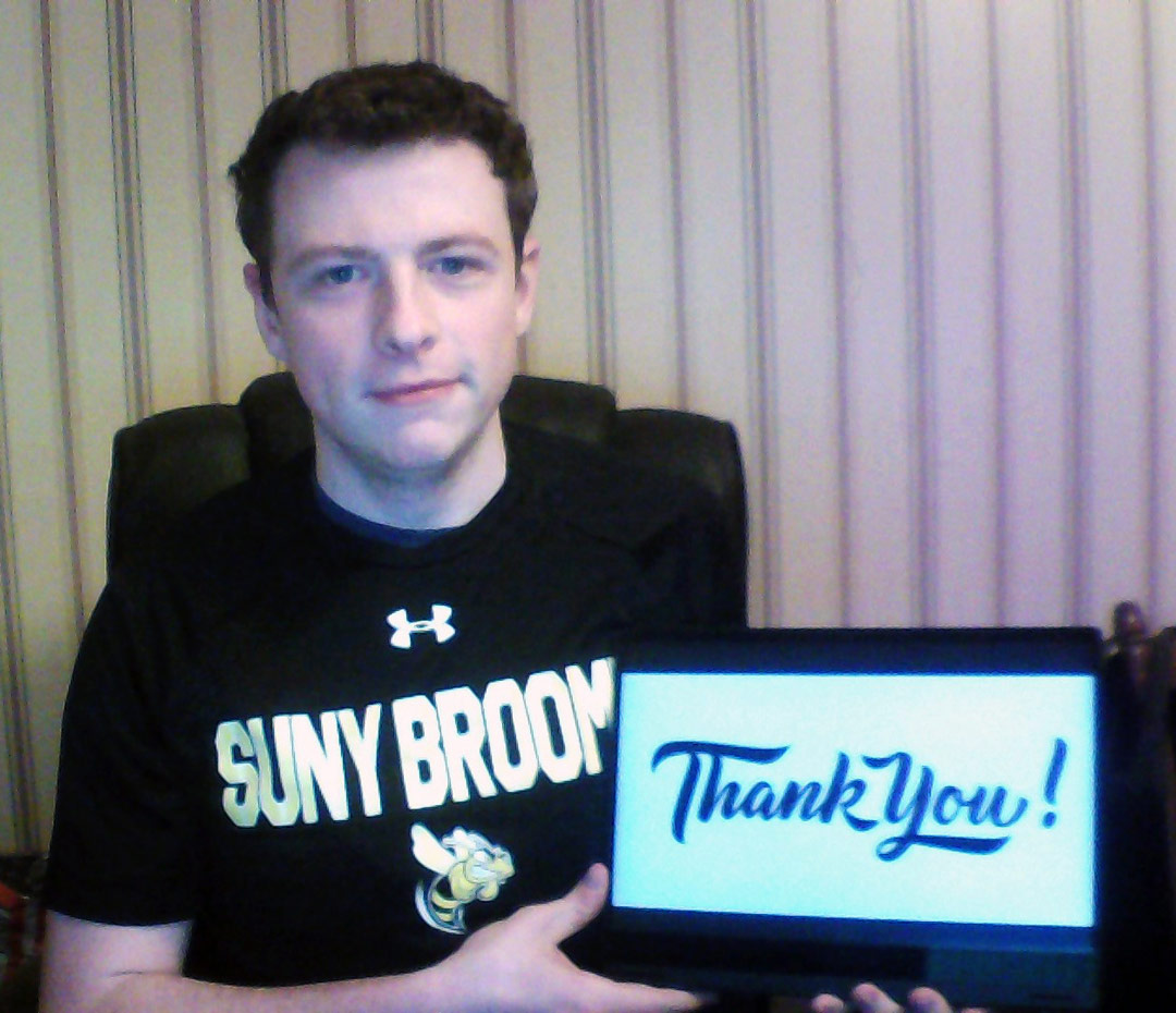 Colby Graef holds up a laptop screen that reads thank you