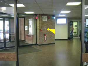arrow pointing to blue light phone in the Business Building Across from the vending area