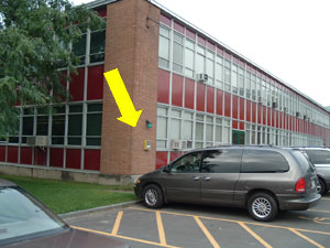 arrow pointing to blue light phone on the Student Services building on the Northeast corner (near Staff Parking Lot #16)